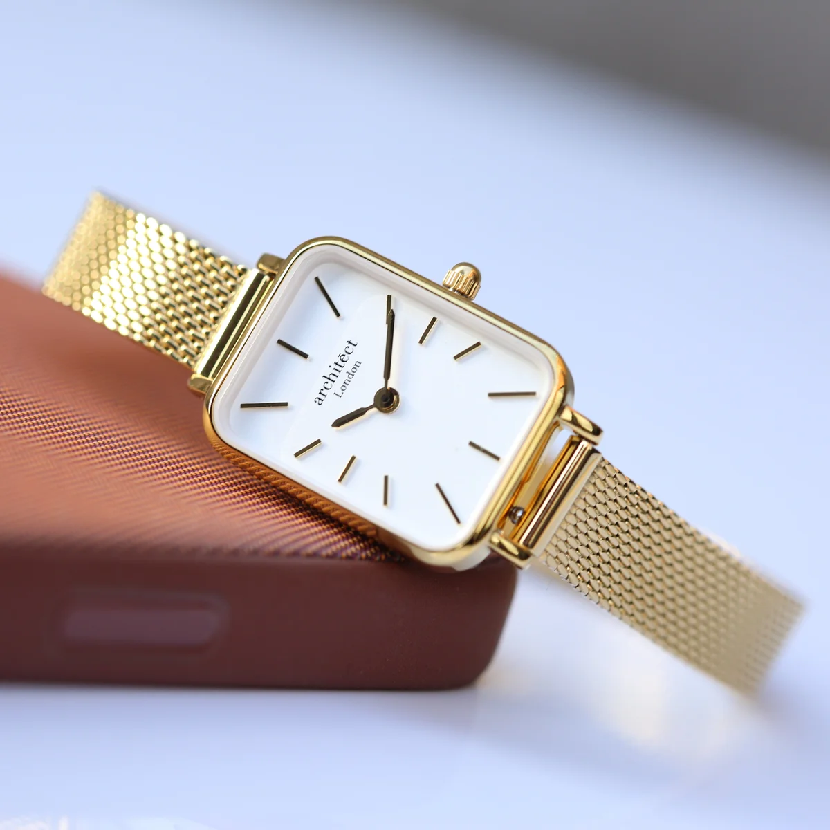 Ladies gold watch with gold mesh strap, minimalist dial, and engraving space on the back, displayed on white background
