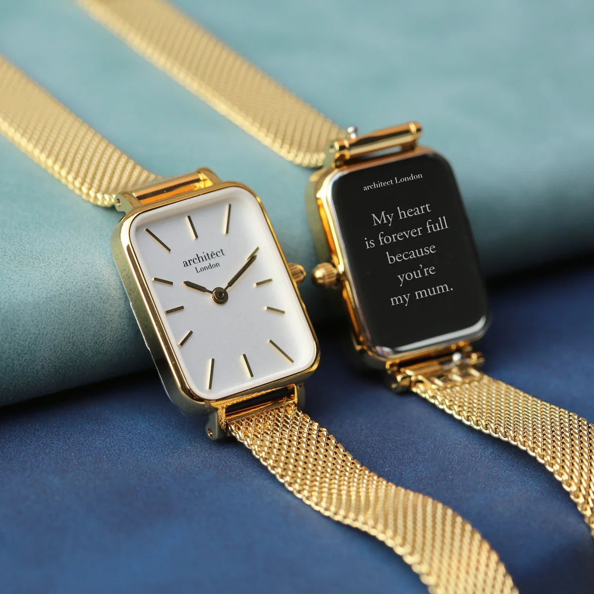 Ladies gold strap watch with minimalist white dial and polished stainless steel case on white background
